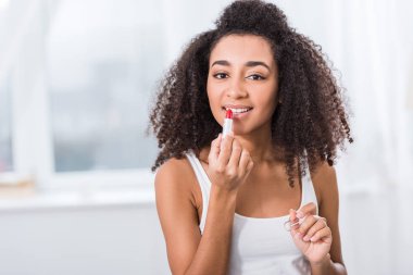 çekici bir Afrikalı-Amerikalı genç kadın kırmızı ruj uygulama 