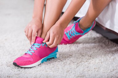 evde yatak odasında spor ayakkabılar üzerinde ayakkabı bağcığı bağlama sporcumuz düşük bölümü