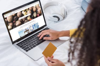 kredi kartı tutan ve depositphotos.com ekranda ile dizüstü bilgisayar kullanarak kadın resim kırpılmış