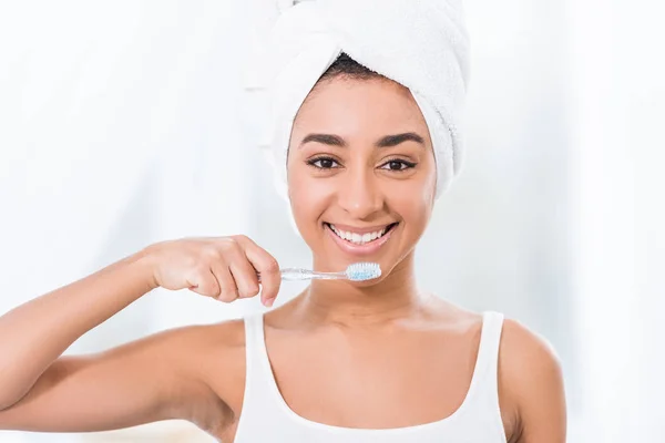 Smiling African American Young Woman Towel Wrapped Head Brushing Teeth — Stock Photo, Image