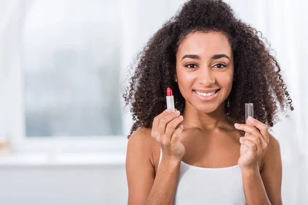 African American Wanita Muda Dengan Rambut Keriting Memegang Lipstik Merah — Foto Stok Gratis