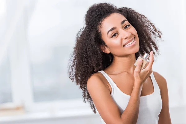 Cheerful African American Curly Girl Using Perfume Home — Stock Photo, Image