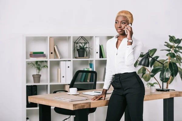 African American Businesswoman Short Hair Talking Smartphone Modern Office — Free Stock Photo