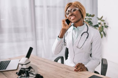  smartphone üzerinde konuşan kadın Afrikalı-Amerikalı bilim adamı 