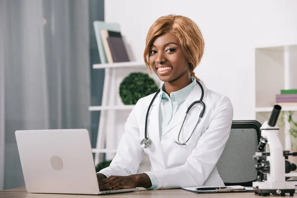 Fröhliche Afrikanisch Amerikanische Wissenschaftlerin Tippt Auf Laptop — kostenloses Stockfoto