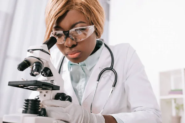 Селективный Фокус Женского Африканского Ученого Американца Рассматривающего Микроскоп — стоковое фото