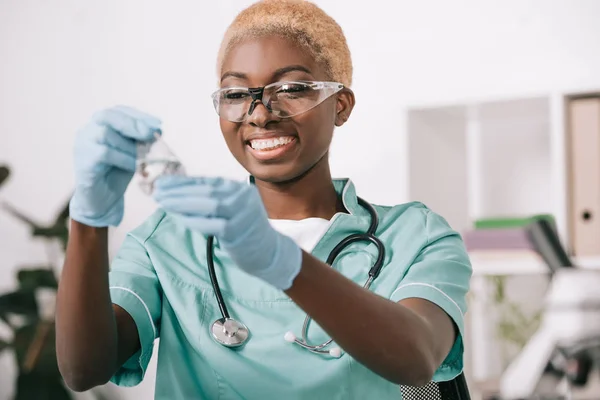 微笑的非洲裔美国科学家拿着实验室瓶 — 图库照片
