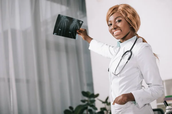 Sonriente Afroamericana Mujer Médico Celebración Rayos Clínica Mientras Mira Cámara — Foto de stock gratis