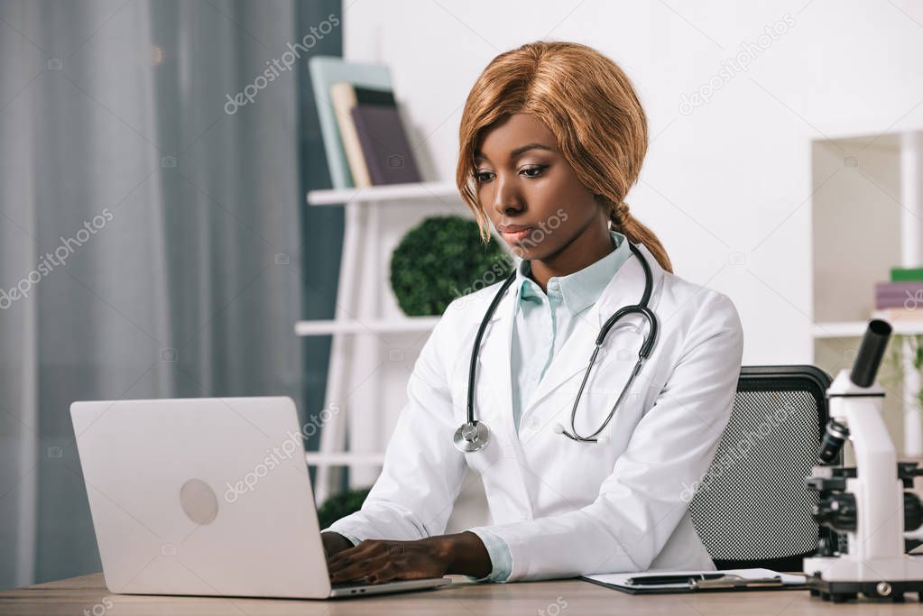 female african american scientist typing on laptop 