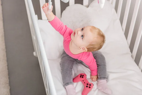 스러운 아이의 장난감을 침대에 조이스틱을 분홍색 셔츠에 — 무료 스톡 포토