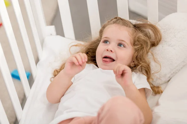 Adorabile Bambino Attaccare Lingua Fuori Sdraiato Culla Nella Stanza Dei — Foto stock gratuita