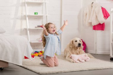 Çocuk odası halı yatan kollarını, golden retriever ile diz ayakta mutlu sevimli çocuk