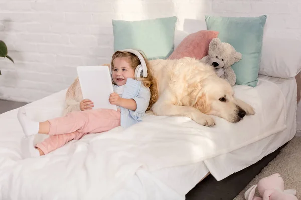 Feliz Adorable Niño Escuchando Música Con Tableta Apoyándose Golden Retriever —  Fotos de Stock