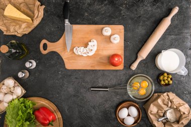 Pizza malzemeleri ve gri arka plan üzerinde mutfak aletleri 