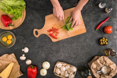 gri arka plan üzerinde pizza malzemeleri ile kesme tahtası üzerinde sebze doğrama kadın görünümünü kırpılmış 