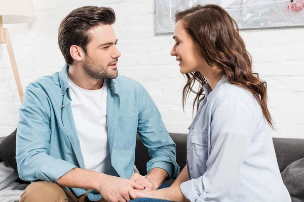 Couple Sitting Couch Looking Each Other Holding Hands Home — Stock Photo, Image