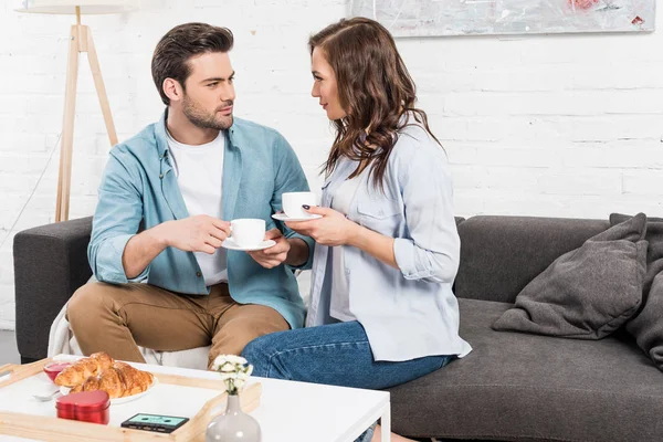 Couple Sitting Couch Looking Each Other Drinking Coffee Breakfast Home — Stock Photo, Image