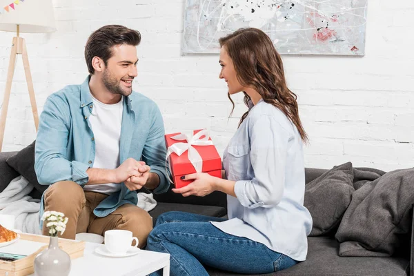 Kvinnan Sitter Soffan Och Presentera Födelsedag Presentask Till Leende Man — Stockfoto