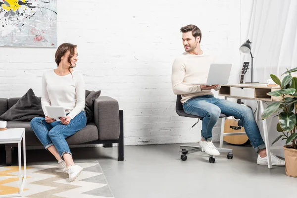 Pareja Usando Dispositivos Digitales Mirándose Sala Estar — Foto de Stock