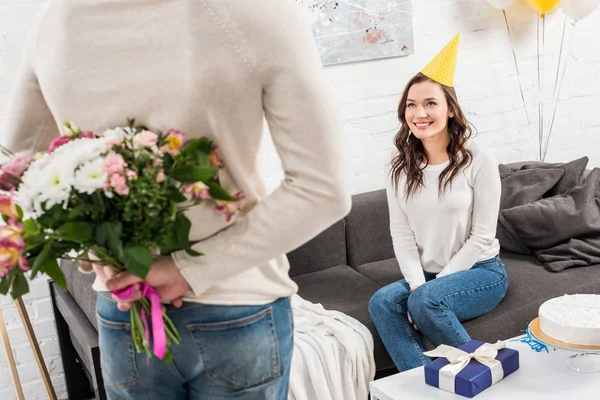 Back View Man Holding Birthday Flowers Back Smiling Woman Sitting — Stock Photo, Image
