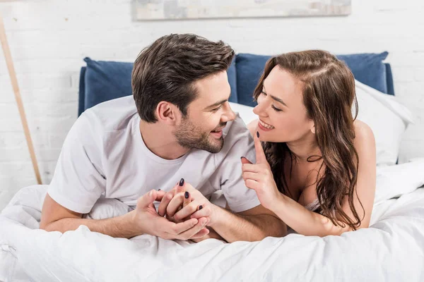 Couple Lying Bed While Woman Smiling Pointing Finger — Stock Photo, Image