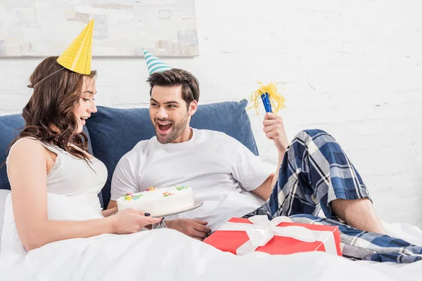 Pareja Emocionada Sombreros Fiesta Acostados Cama Celebrando Cumpleaños Con Pastel — Foto de Stock