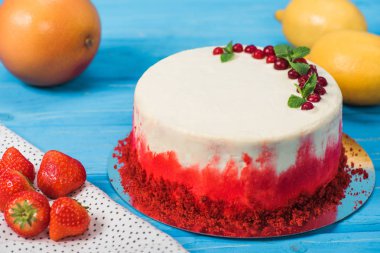 beyaz pasta kırmızı kuş üzümü ile dekore edilmiş kapatmak ve portakal ve limon nane yaprakları