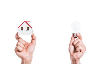 cropped view of male hands holding house model and led lamp in hands isolated on white, energy efficiency at home concept clipart