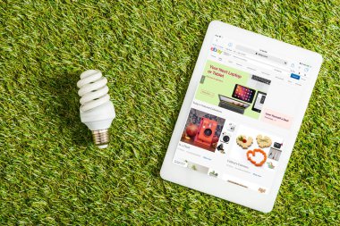 floresan lamba ile ebay app dijital tablet yakınındaki üstten görünüm ekranda yeşil çimen, enerji verimliliği kavramı