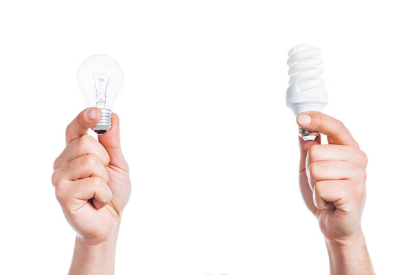 cropped view of  male hands holding led and fluorescent lamps isolated on white, energy efficiency concept