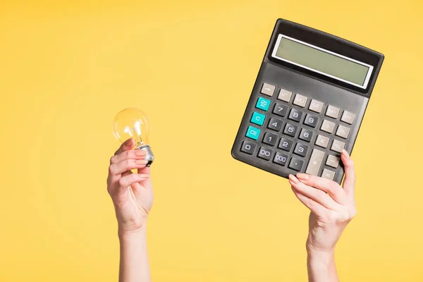 Cropped View Woman Holding Led Lamp Calculator Hands Isolated Yellow — Stock Photo, Image