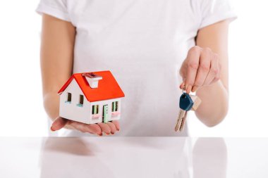 kısmi görünümünü ev modeli ve beyaz, ipotek kavramı izole anahtarları tutan kadın