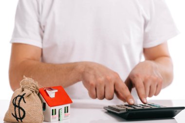 adamın beyaz, ipotek kavramı izole paran ve ev model yakınındaki hesaplama kısmi görünümü