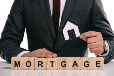 holding kağıt ev ahşap bloklar üzerinde beyaz izole yakınındaki ipotek komisyoncusu kırpılmış görünümünü