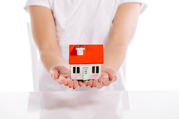 cropped view of woman holding house model isolated on white, mortgage concept