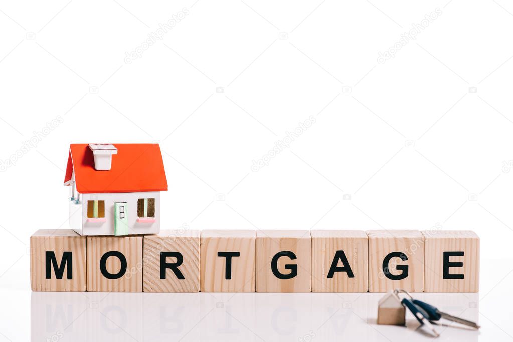 wooden blocks with mortgage lettering, house model and keys isolated on white 
