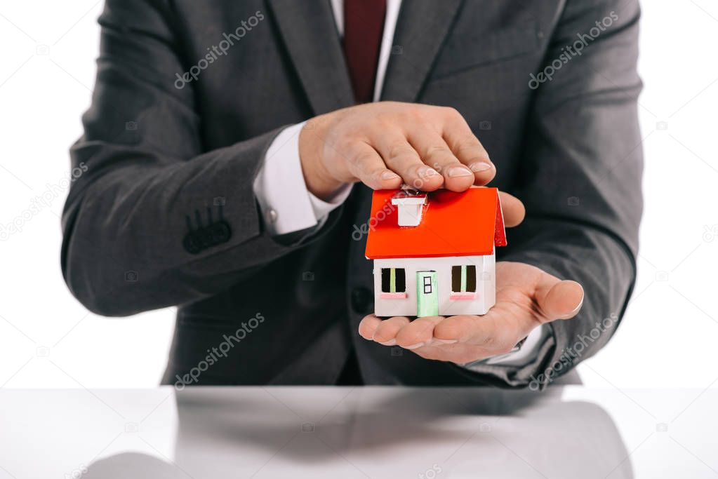 partial view of mortgage broker holding house model isolated on white