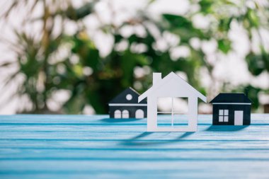 selective focus of paper houses on wooden desk, mortgage concept clipart