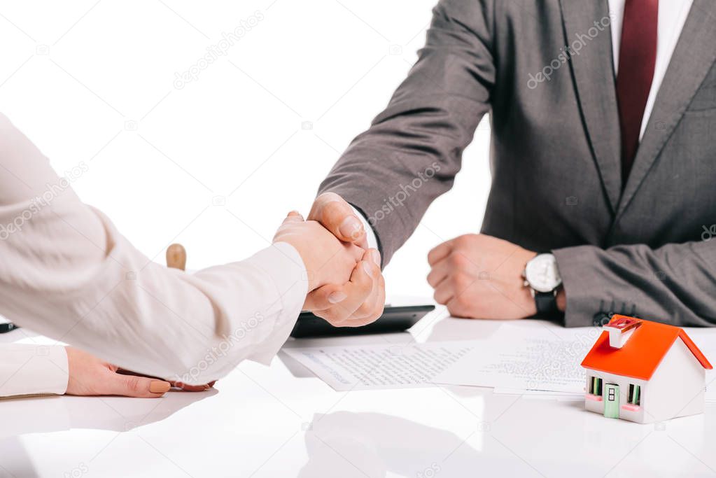 cropped view of businessman and woman shaking hands isolated on white, mortgage concept