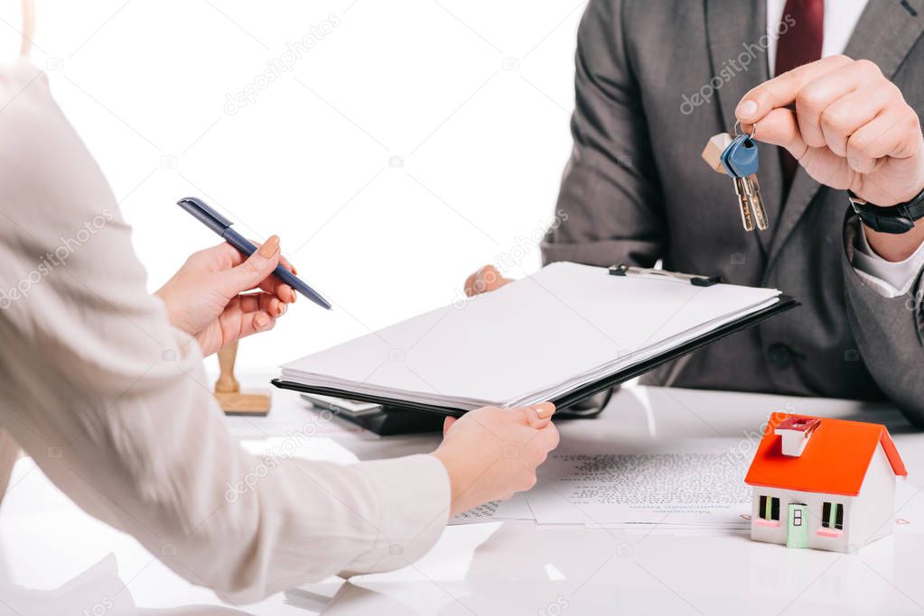 cropped view of mortgage broker and woman making deal and holding keys isolated on white, mortgage concept