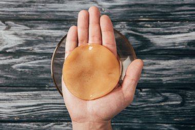 kombucha mantar elinde tutan adam üstten görünüm 