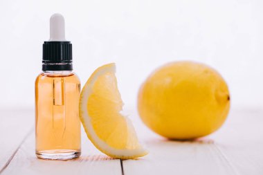 CBD petrol şişe damlalık ve ahşap yüzeyi üzerinde beyaz izole limon ile
