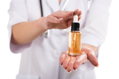 bir kadın doktor cdb petrol ve üzerinde beyaz izole damlalık şişe tutan kırpılmış görünümü