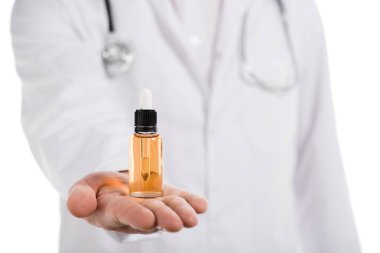 cropped view of male doctor holding bottle with cbd oil on hand isolated on white clipart