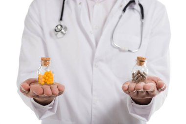 cropped view of male doctor holding two bottles with pills isolated on white clipart