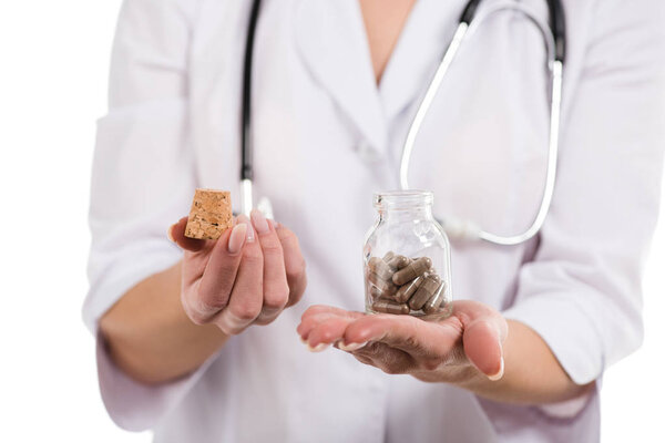 cropped view of female doctor opening up bottle with pills isolated on white
