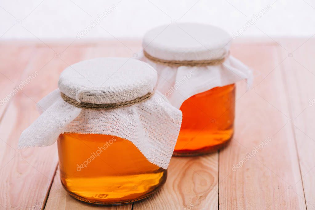 selective focus of bottled fermented tea in jars isolated on white