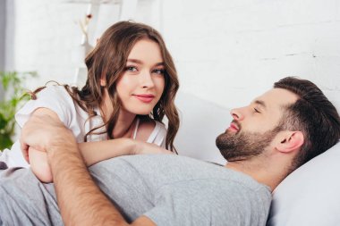 Genç çift yatakta nazik sarılma sevgi dolu seçici odak 