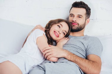 Yetişkin sevgi dolu kadın nazik kucaklayan adam yatakta 