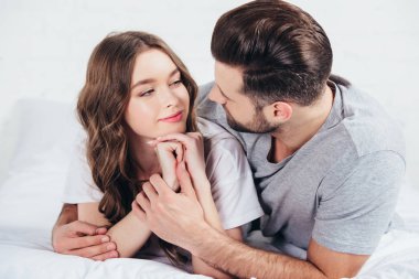 sarılma ve yumuşak yatakta yatan genç aşıkların seçici odak